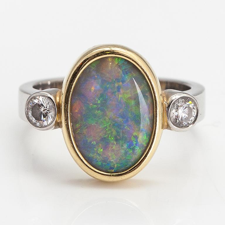 A platinum and 18K gold ring with an opal and diamonds ca. 0.20 ct in total.