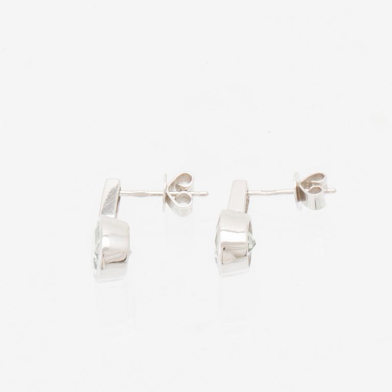 A pair of 18K white gold earrings set with oval faceted aquamarines and round brilliant-cut diamonds.