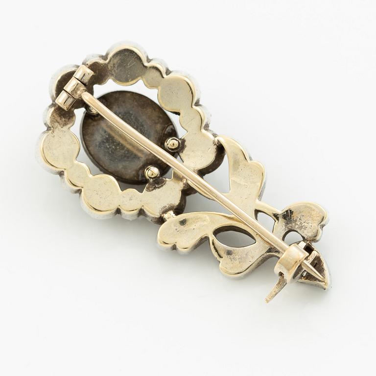 Brooch in silver set with rose-cut diamonds in the shape of a flower.