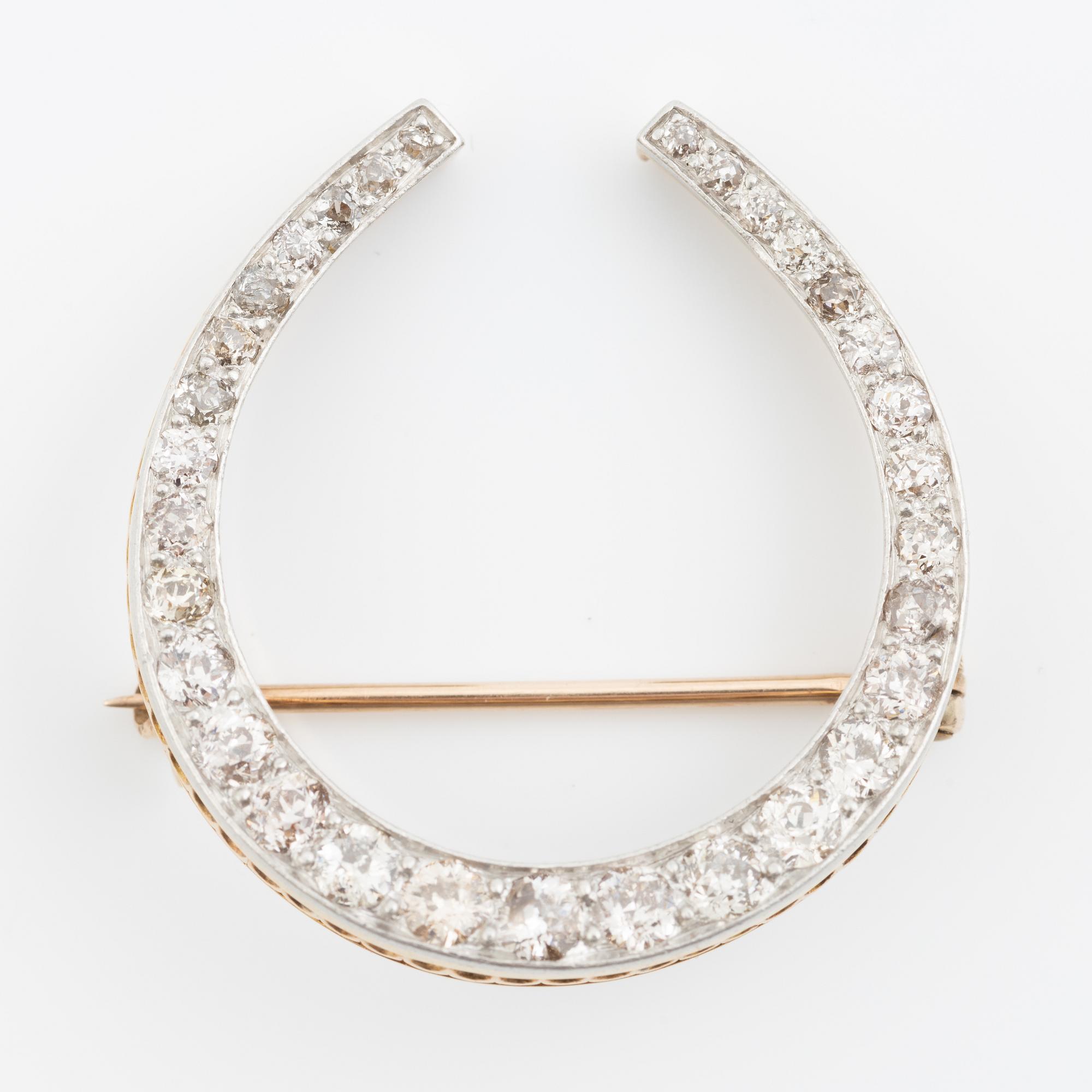 Brosch i form av hästsko, 14K och platina med gammalslipade diamanter totalt ca 1.80 ct, omkring sekelskiftet 1900.