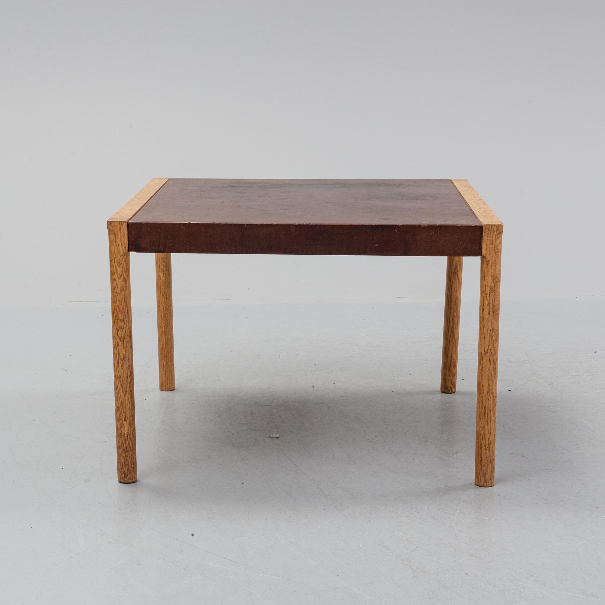 An oak and leather coffee table, mid 20th Century.
