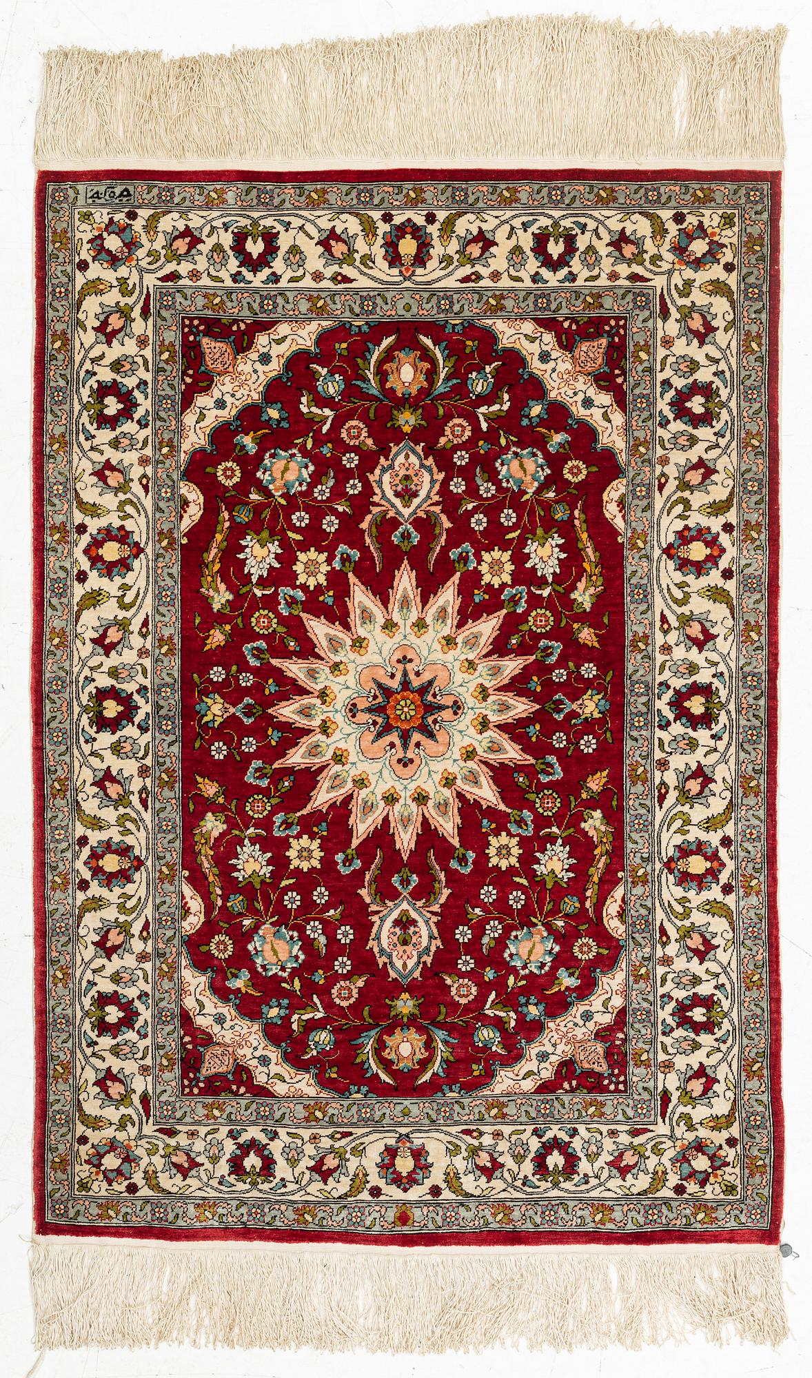 A silk Hereke rug, circa 91 x 63 cm.