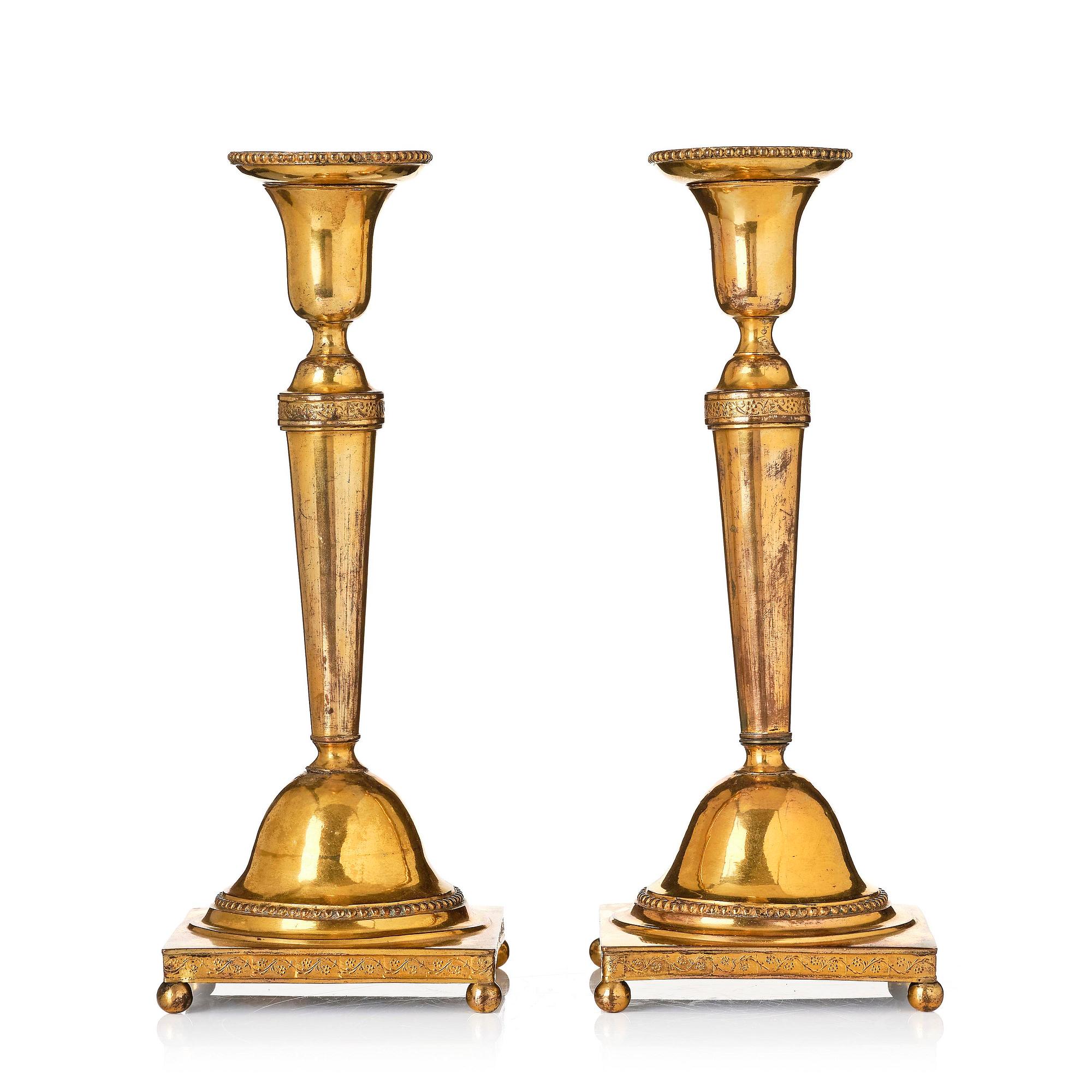 A pair of late George III gilt-copper candlesticks, early 19th century.