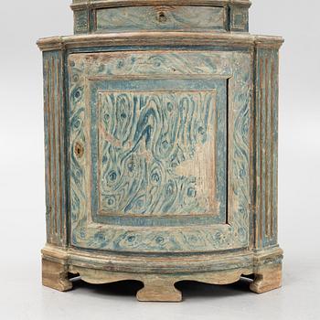 A marbeled corner cabinet, 18th Century.