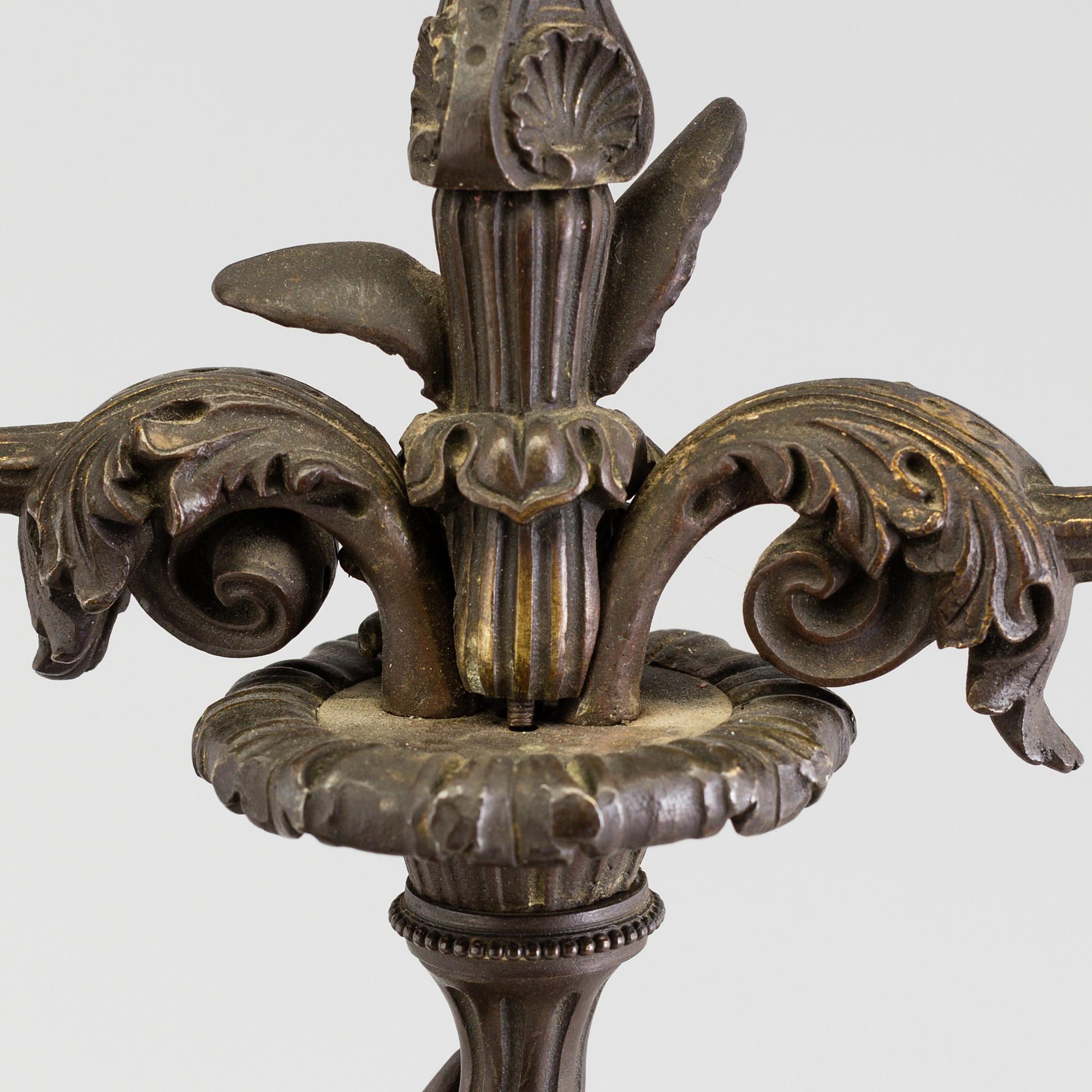 A pair of late 19th century patinated brass candelabra.