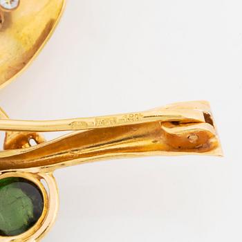 An 18K gold brooch in the form of a parrot with colored gemstones and round brilliant-cut diamonds.