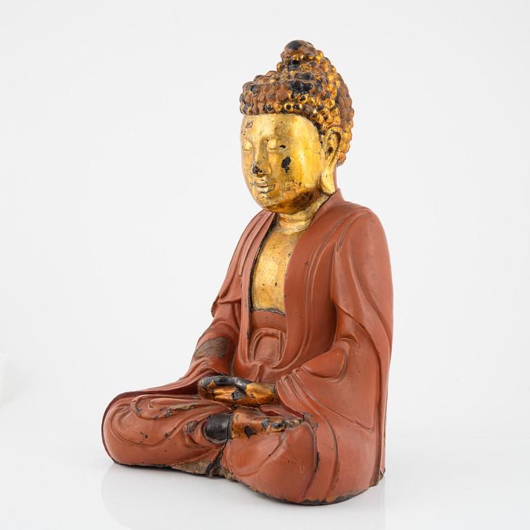 A large Vietnamese gilt and lacquered wooden buddha, circa 1900.