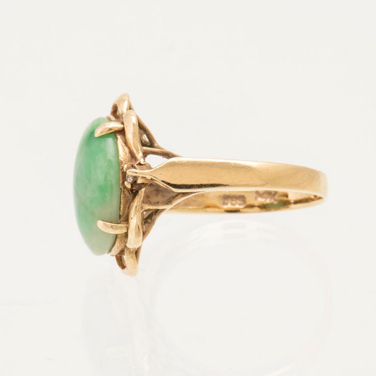 Ring in 14K gold with a green oval cabochon-cut stone and round brilliant-cut diamonds.