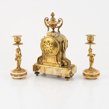 A pair of candelabras and a mantel clock, Louis XVI-style, circa 1900.