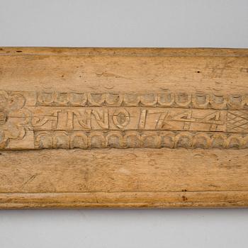 A Swedish folk art mangle board with carved decorationd, owners' initials and the date 1744.