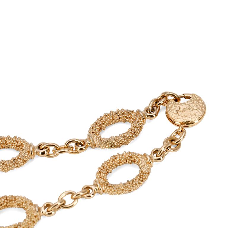 YVES SAINT LAURENT, a gold colored necklace with a pair of earclips.