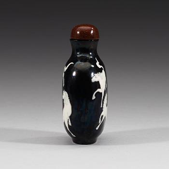 An enamelled porcelain snuff bottle with stopper, Qing dynasty (1644-1912).