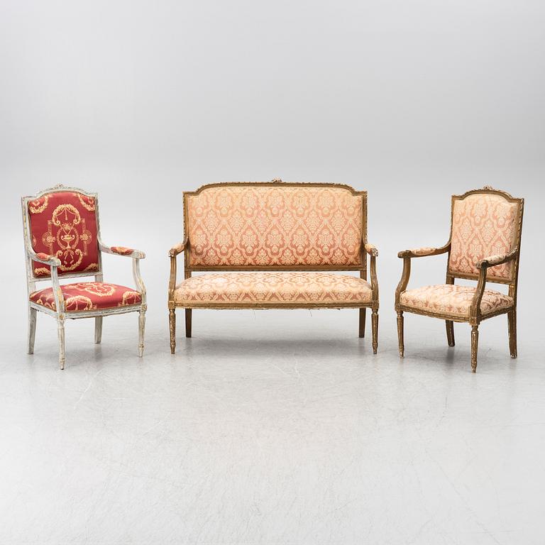 A pair of Louis XVI-style armchairs and a sofa, 20th century.
