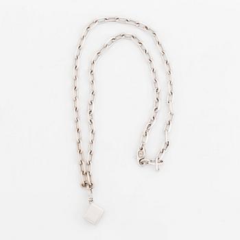 An 18K gold and white gold Cartier necklace with a charm.