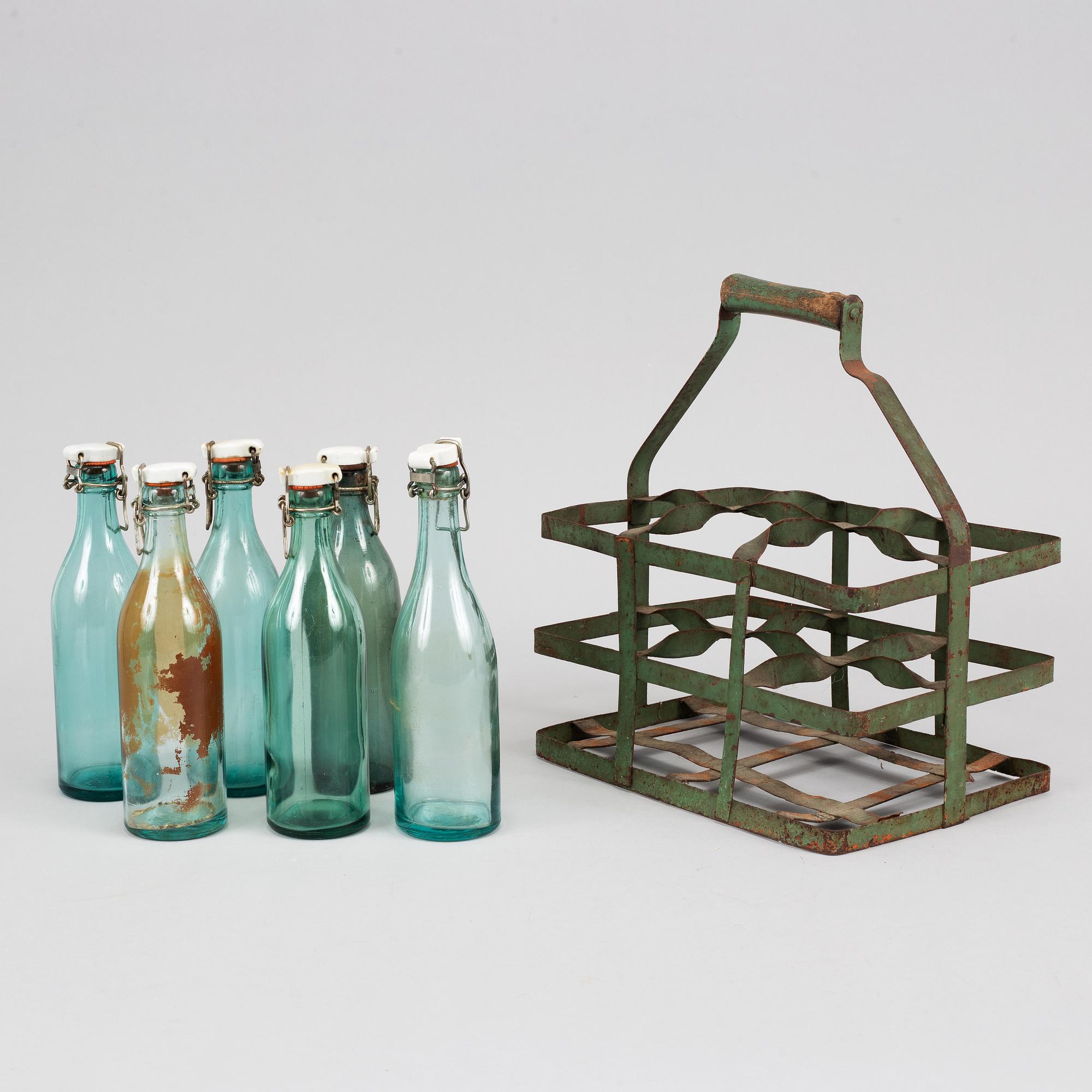 A 19th century tinplate bottle stand with six glass bottles.