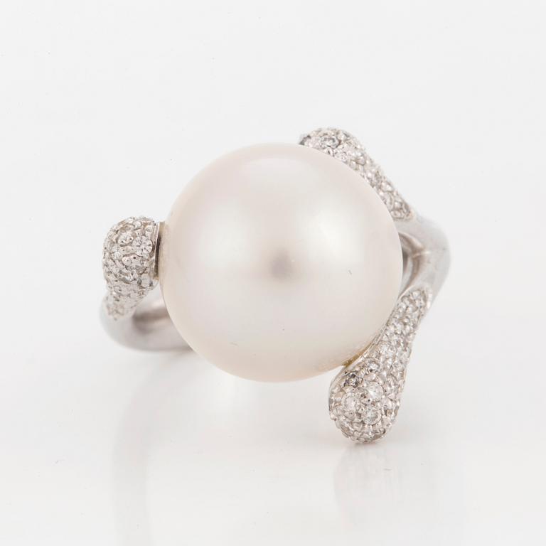 A ring set with a cultured 'South Sea' pearl and round, brilliant-cut diamonds.