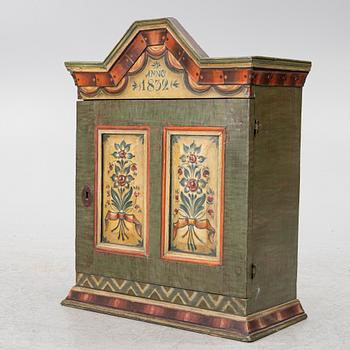 A hanging cabinet, dated 1832.