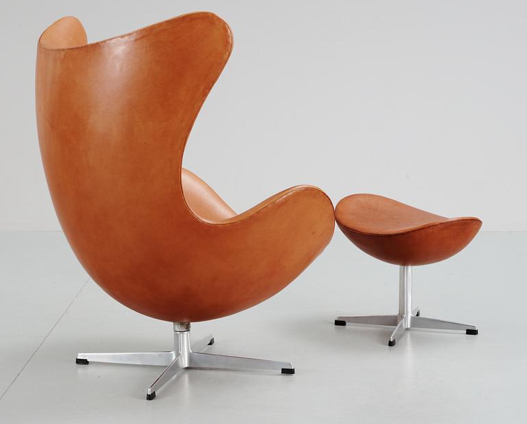 An Arne Jacobsen brown leather 'Egg' chair and ottoman, Fritz Hansen, Denmark 1963.