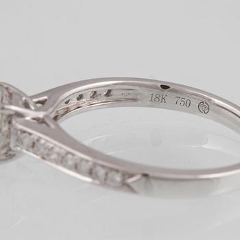 RING, 18K vitguld med briljantslipad diamant ca 0.85 ct samt 14 briljantslipade diamanter 0.15 ct. Vikt 3,1 gram.