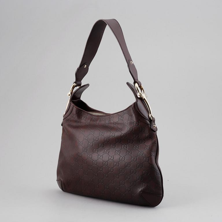 Gucci, a leather bag.