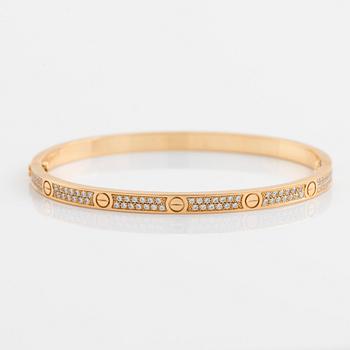 A Cartier "Love" bracelet small model in 18K gold set with round brilliant-cut diamonds.