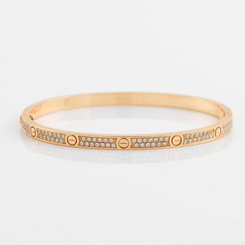 A Cartier "Love" bracelet small model in 18K gold set with round brilliant-cut diamonds.