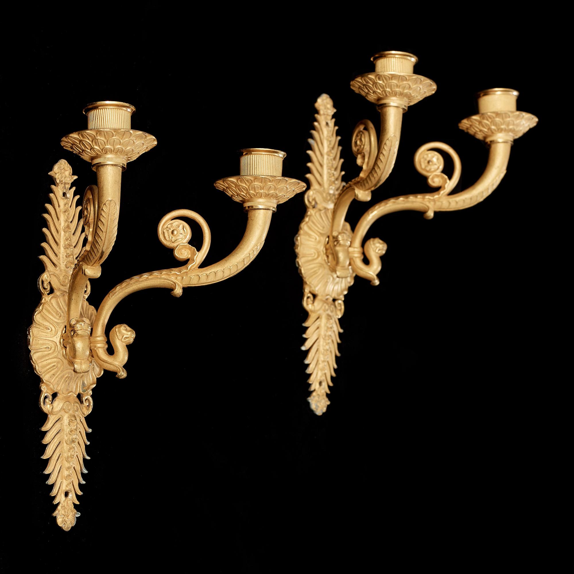 A pair of Empire early 19th century gilt bronze two-light wall-lights.