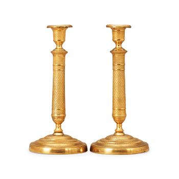 1462. A pair of French Empire early 19th century gilt bronze candlesticks.