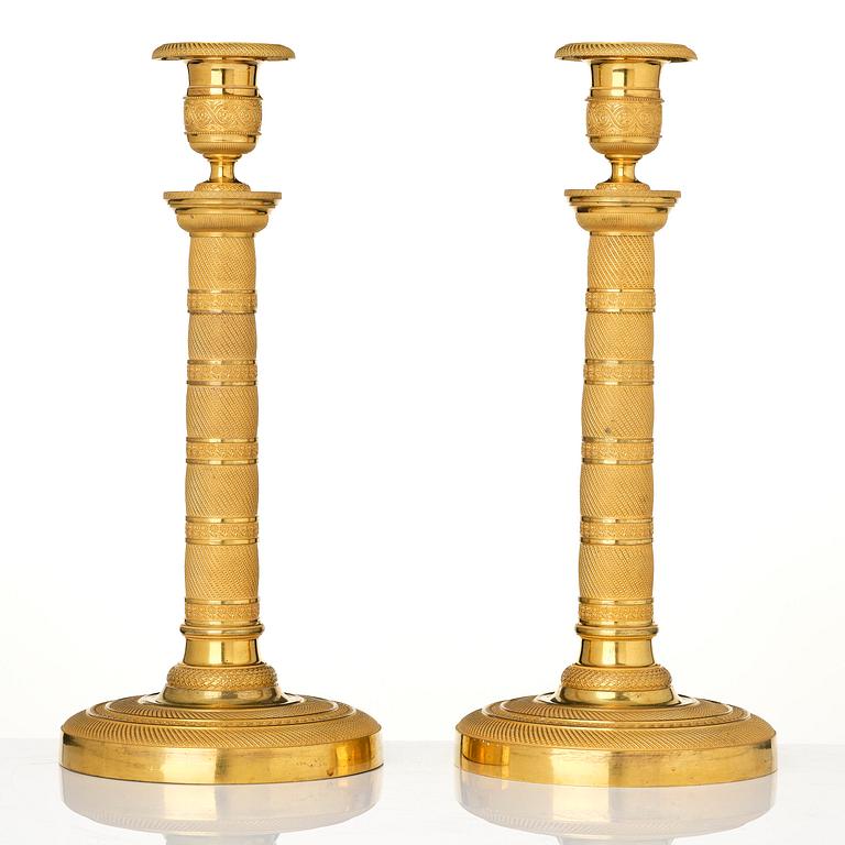 A pair of French Empire gilt-bronze candlesticks, early 19th century.