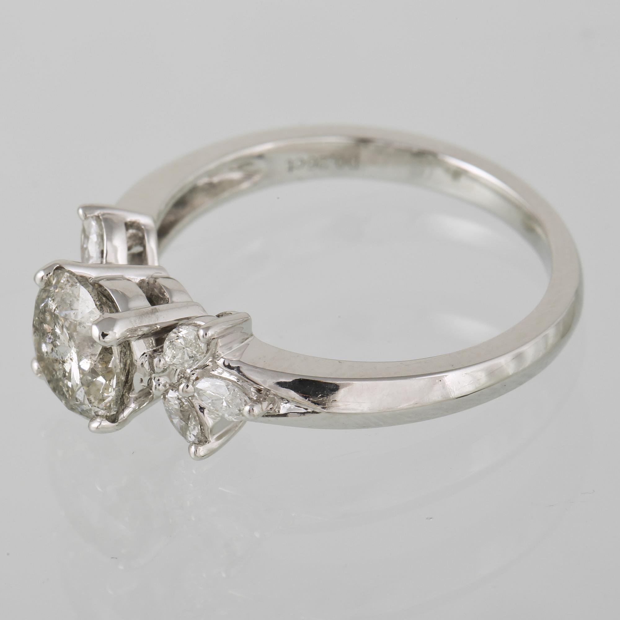 RING, 18K vitguld med briljantslipad diamant ca 1.22 ct samt navetteslipade diamanter 0.26 ct. Vikt 4,2 gram.