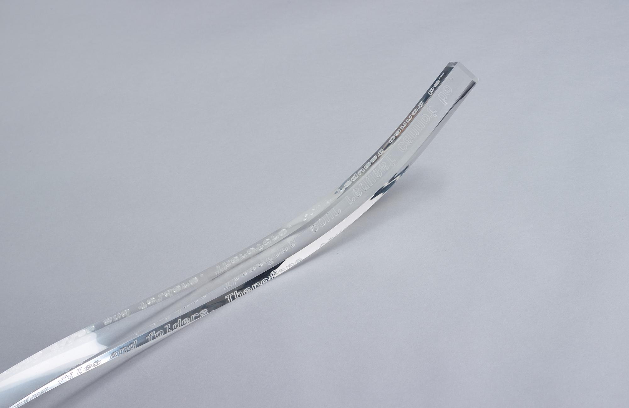 Yngve Holen, executed in 2014. Engraved acrylic glass, cable, lock, trainer, snap bracelet.