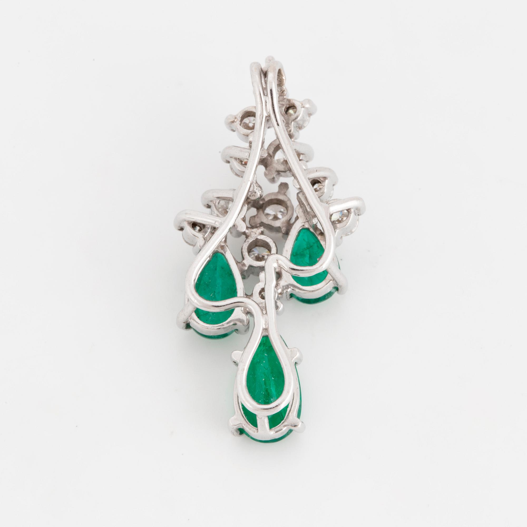 An 18K white gold emerald and diamond pendant.