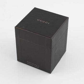 Gucci, a scented candle.