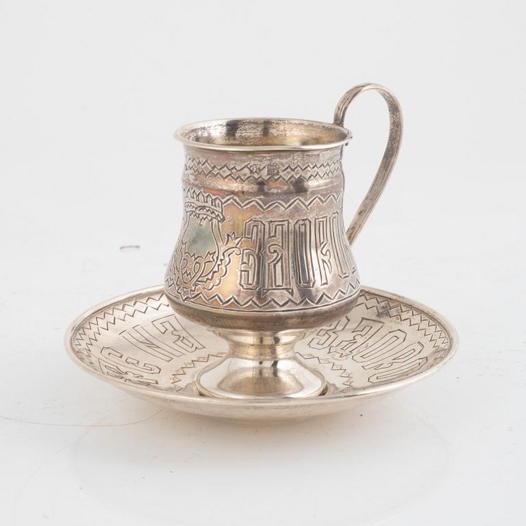 A silver teacup and saucer, possibly Pavel Perepyekin, Moscow 1885 and silver tea glass holder, 1891.