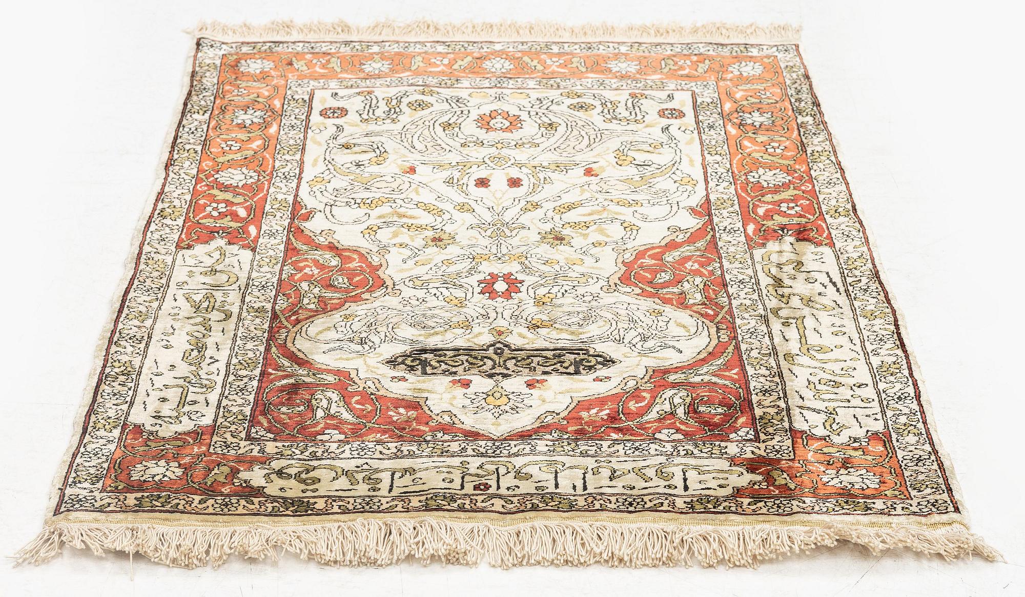 A silk and metal Hereke rug, c. 80 x 51 cm.