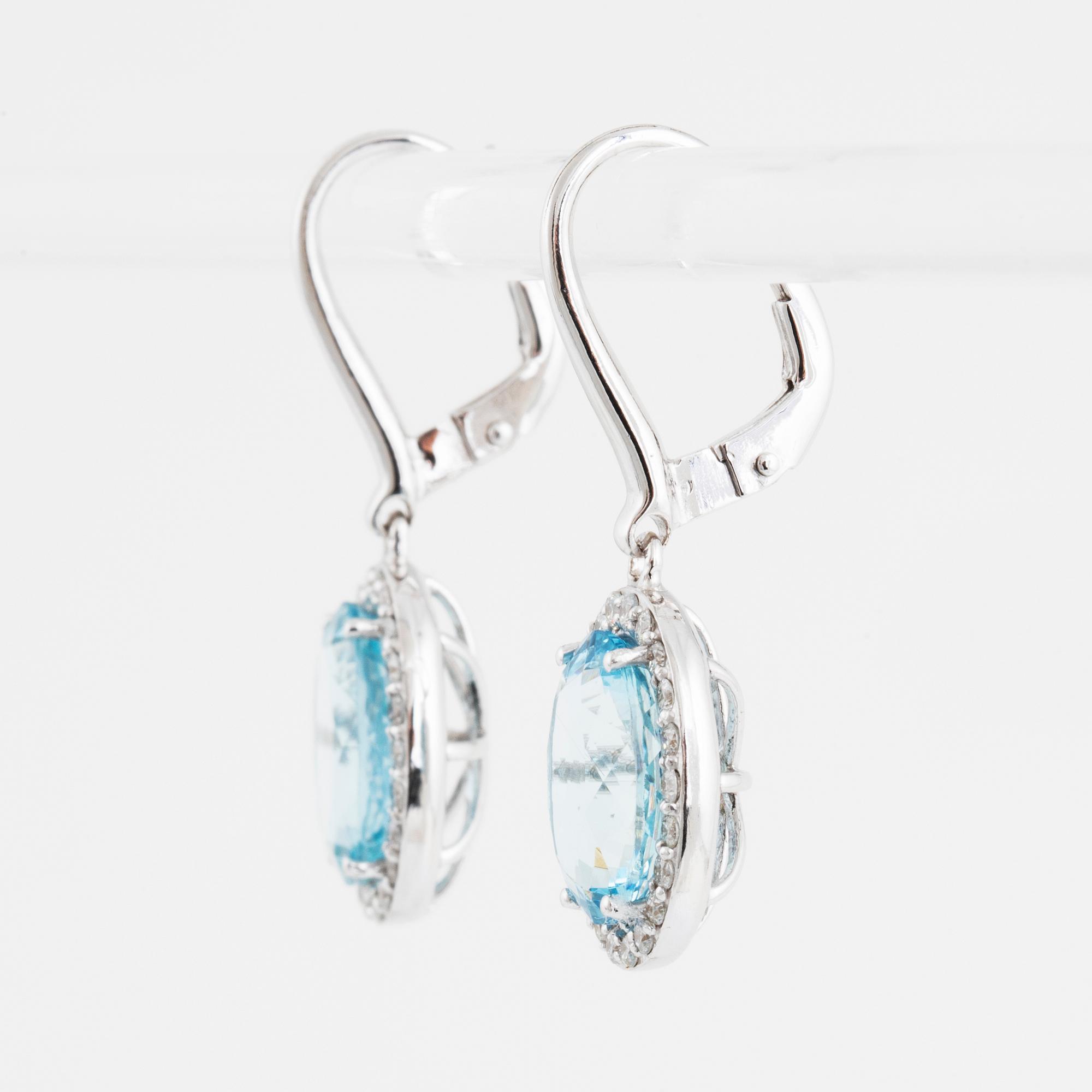 A pair of 18K gold earrings set with faceted aquamarines.