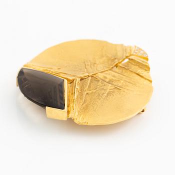 Brosch, 18K guld med fantasislipad rökkvarts och runda briljantslipade diamanter.