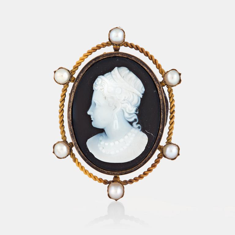 A hard stone cameo brooch in 18K gold set with pearls.