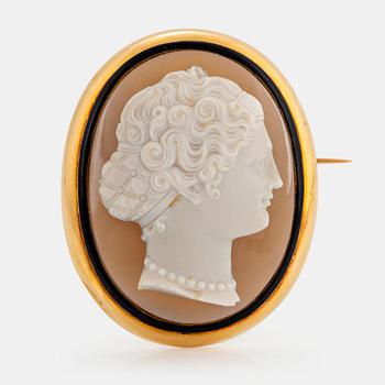 1111. An 18K gold and black enamel brooch with a hardstone cameo.