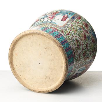 A Canton famille rose jar with cover on a tall wooden stand, Qing dynasty, late 19th Century.