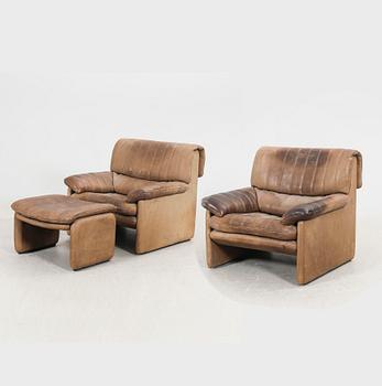 A set of two leather armchairs and a stool by De Sede, Schweiz second half of the 20th century.