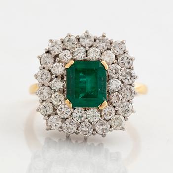 Ring, 18K guld, smaragdslipad smaragd ca 2 ct, med 32 briljantslipade diamanter totalt ca 2 ct.
