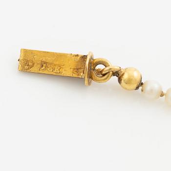 Necklace of pearls with an 18K gold clasp.