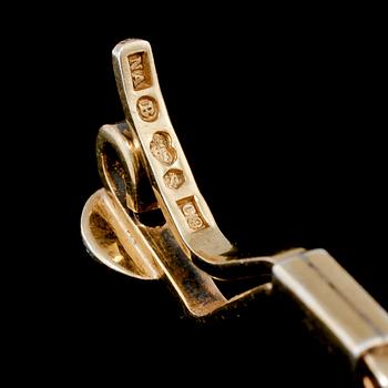 SPÄNNE, 18k guld med 2 briljantslipade vita stenar, Nils Ahlström, Borås, 1953. Vikt 6 g.