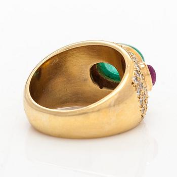 An ca 18K gold ring, with a cabochon-cut emerald and rubies, and brilliant-cut diamonds.