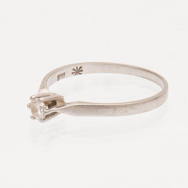 An 18K white gold ring with a round brilliant cut diamond.