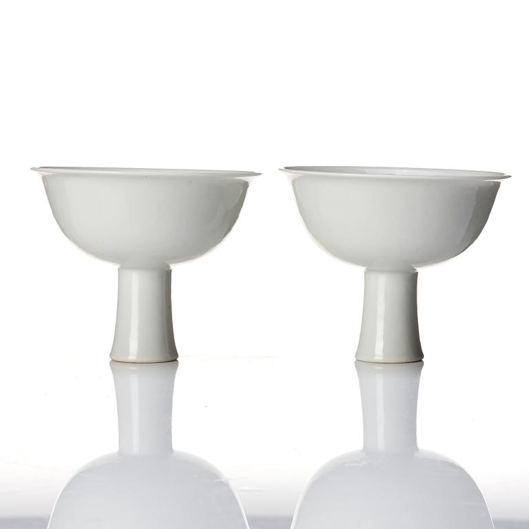 A pair of white glazed anhua stemcups, Qing dynasty, 19th Century.