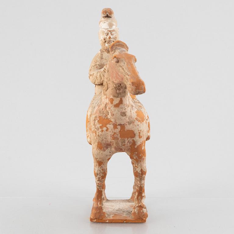 A painted pottery figure of an equestrian standard-bearer, Tang dynasty (618-907 AD.).