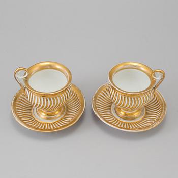 a pair of late empire porcelain cups with saucers from the first half of the 19th century.
