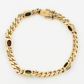 Bracelet in 18K gold set with cabochon-cut emeralds, rubies, and sapphires.